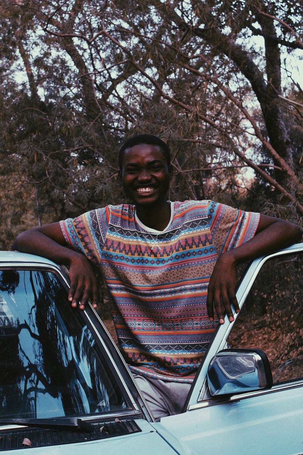 Happy car owner smiling beside an everyday vehicle